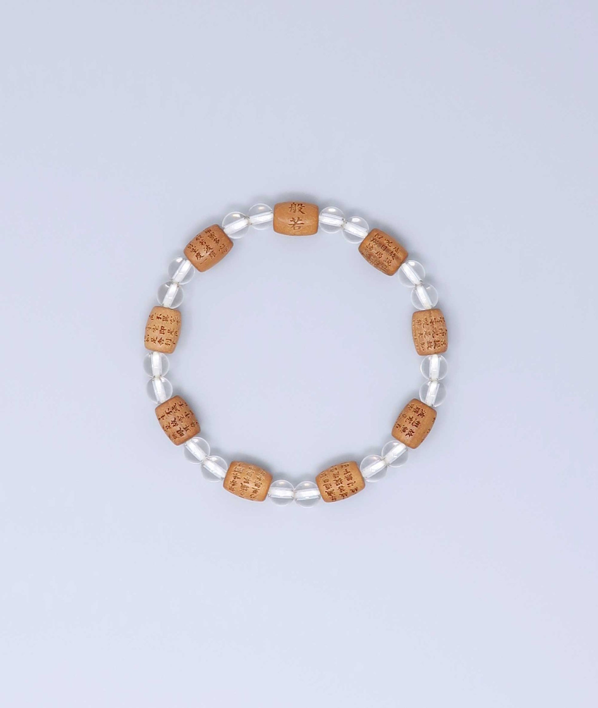 Sandalwood bracelet engraved with the Heart Sutra and accented with a Clear Quartz bead—handcrafted for spiritual protection and harmony. Handcrafted in Kyoto Japan Kanbe Juzu