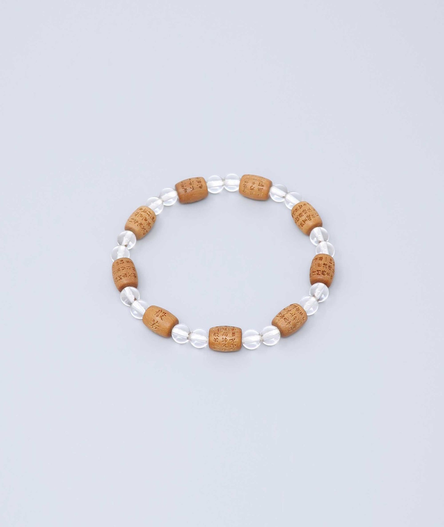 Sandalwood bracelet engraved with the Heart Sutra and accented with a Clear Quartz bead—handcrafted for spiritual protection and harmony. Handcrafted in Kyoto Japan Kanbe Juzu